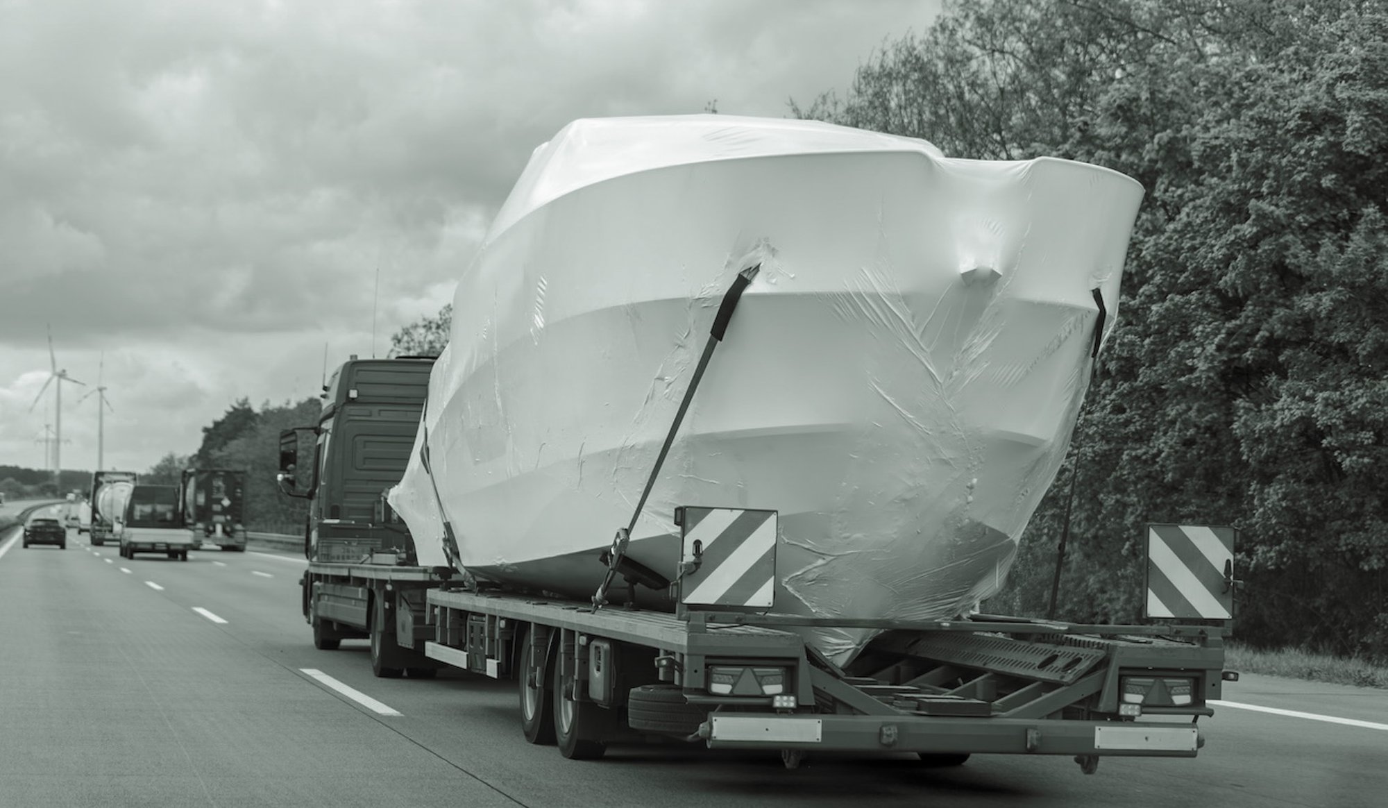 truck-semi-trailer-carrier-towing-new-wrapped-yach-2025-03-12-18-20-39-utc